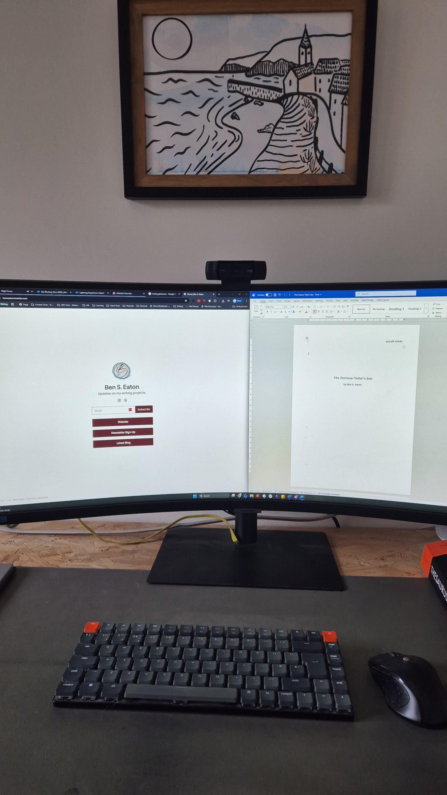 A desk with two screens and a keyboard visible