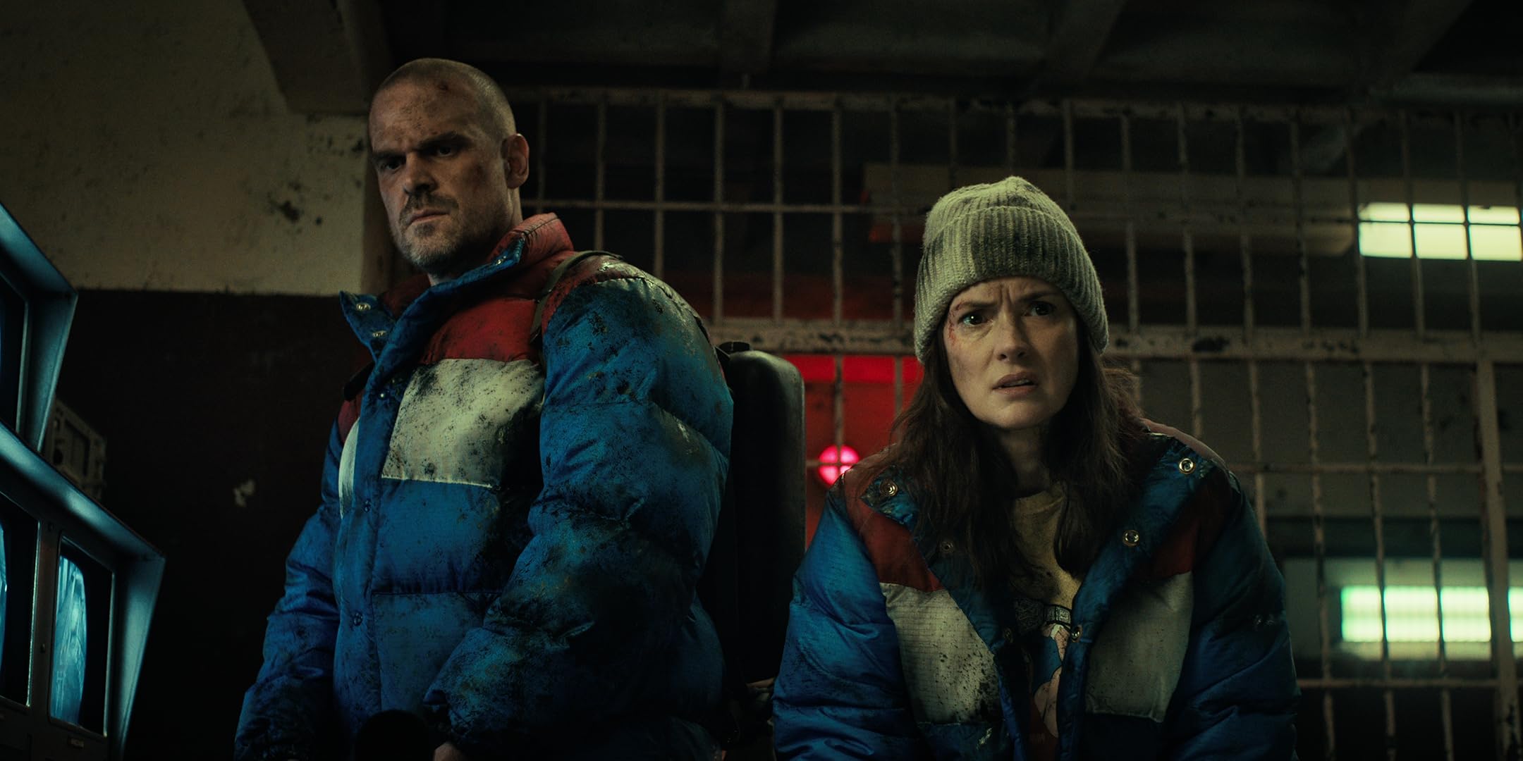 Hopper and Joyce dressed in parkas, very grubby, in a Russian prison