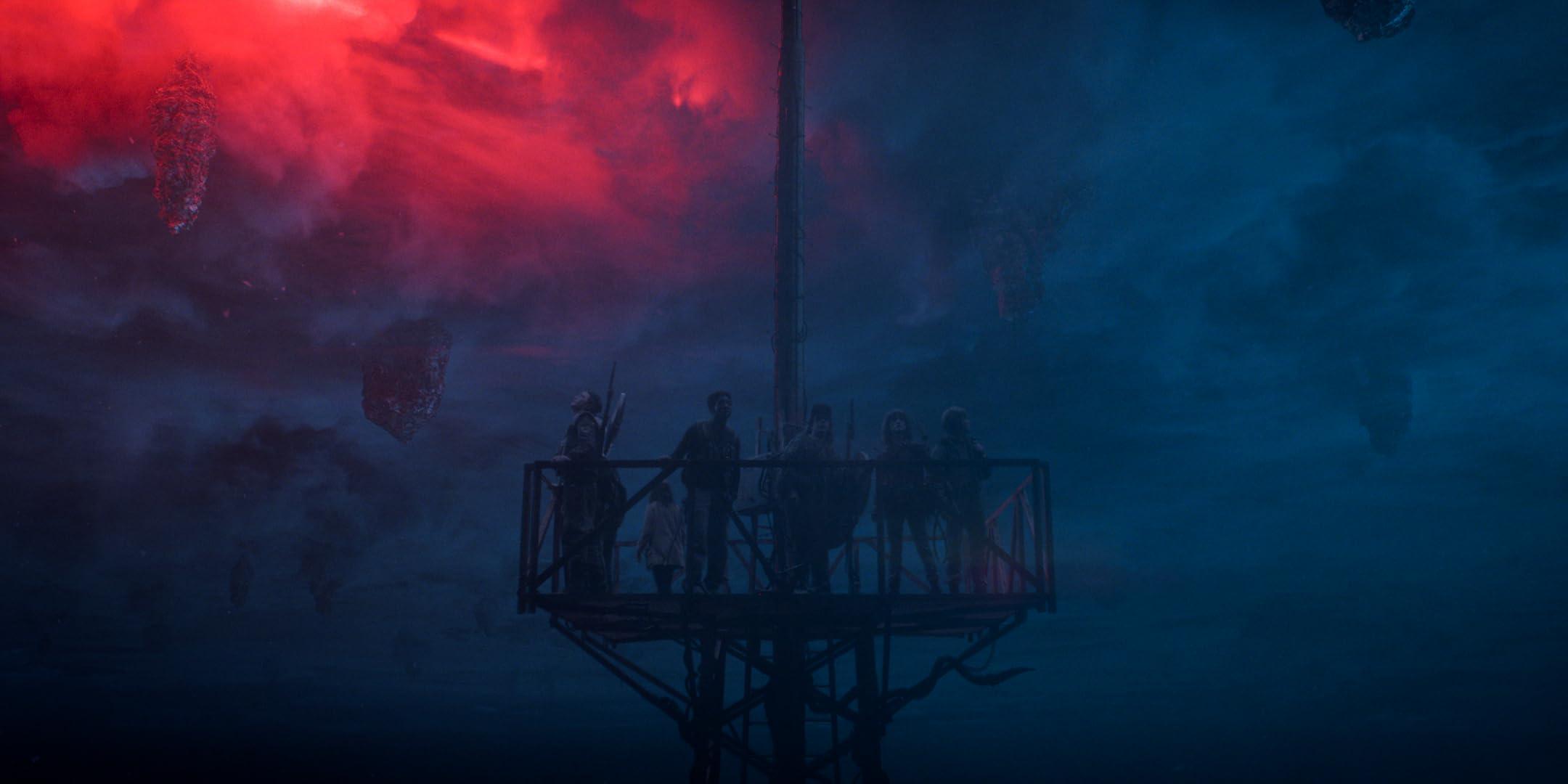 Still from Stranger Things episode 8, the kids look up at a dark and red storm cloud filled sky