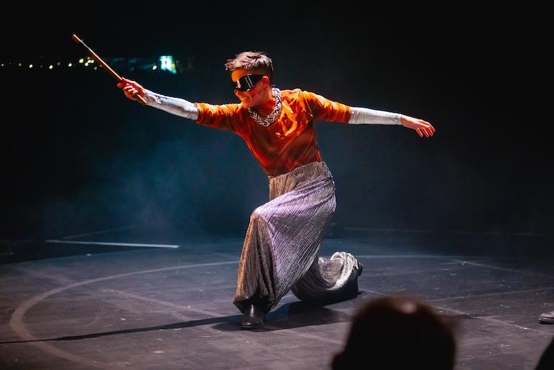 A scene from Asian Pirate Musical shows a performer wielding a stick