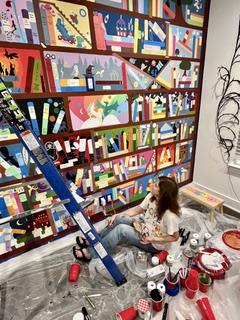 Author Berna Hudson painting a mural