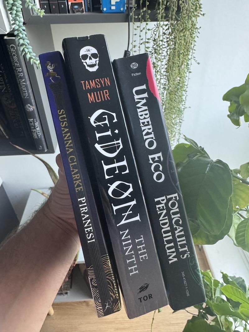 Copies of the books Piranesi by Susanna Clarke, Gideon the Ninth by Tamsyn Muir, and Foucalt's Pendulum by Umberto Eco