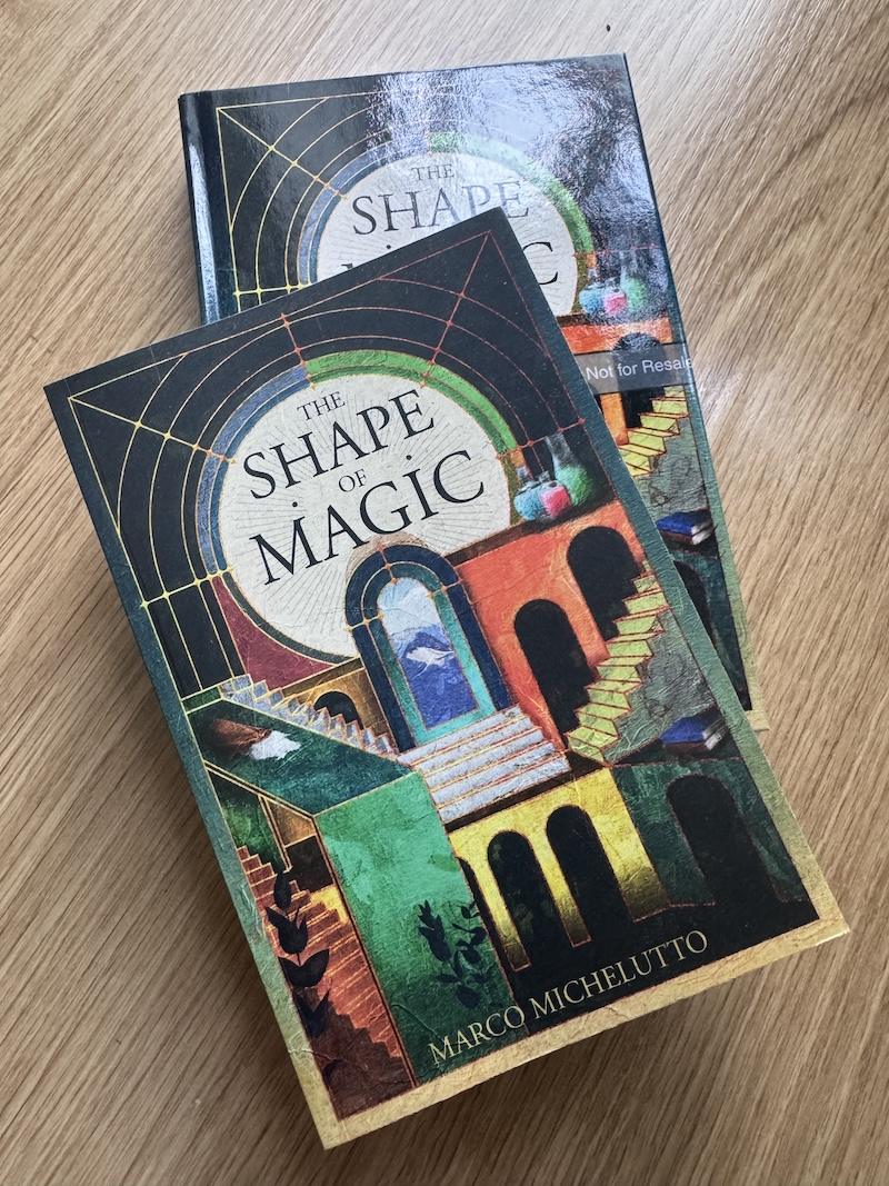 Two copies of the book The Shape of Magic by Marco Michelutto