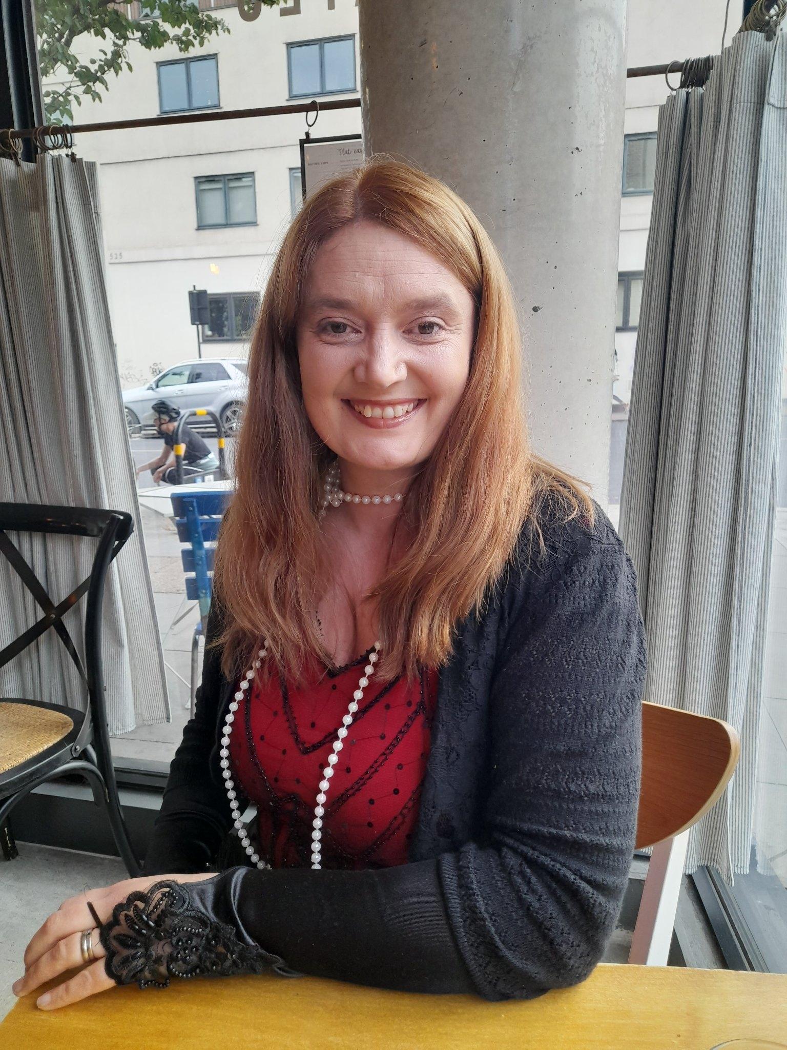 Author Anna Orridge sits at a table in a cafe